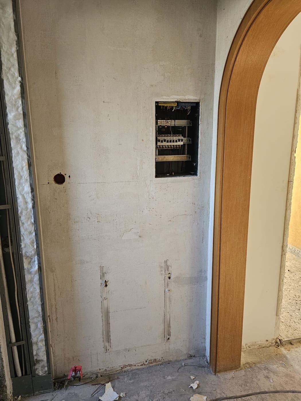 Alte Unterverteilung in einer Wandnische, darunter die gestemmten Schlitze für die neuen Leitungen.